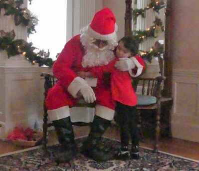 Little girl hugging Santa Clause at the Lawrence County Historical Society Open House with Santa.