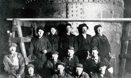 Small group of male workers inside a factory