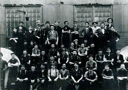 Large group of male workers sitting in rows posing for photo
